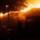 A firefighter defends a structure against approaching flames while in Geyserville.